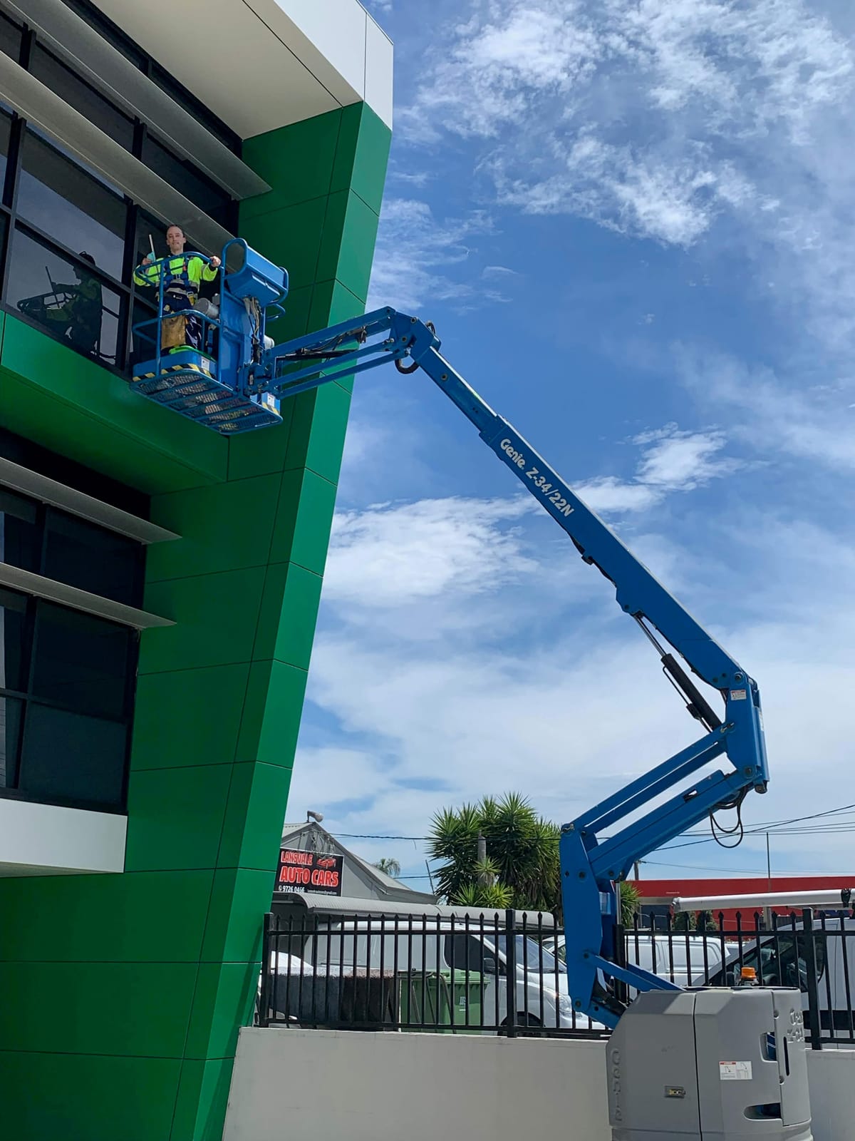 Commercial window cleaning Sydney — Wash My Windows technician on boom lift servicing office building exterior